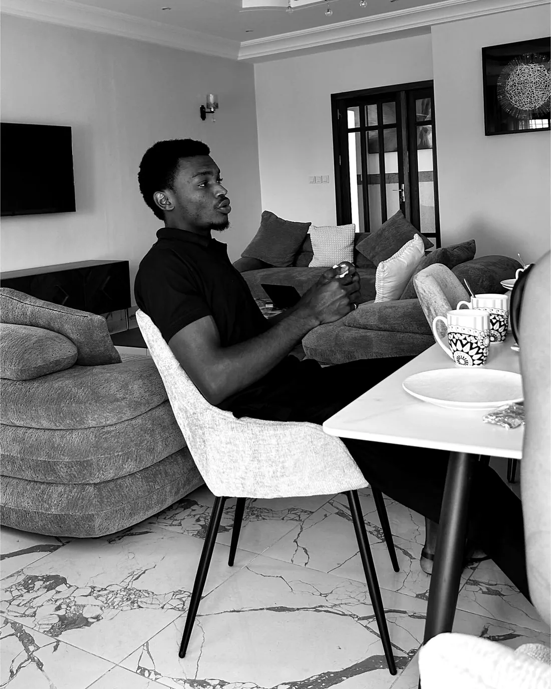 Darryl Wassi sitting in a living room, thinking